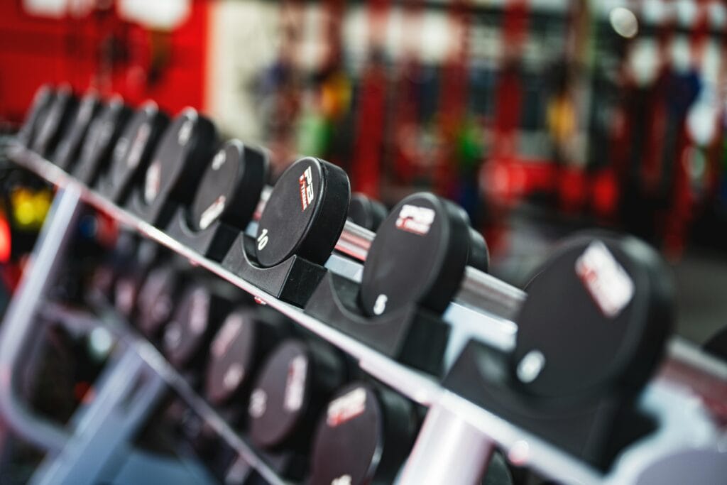 Close-up view of dumbbells in a modern gym setting, emphasizing fitness and training.